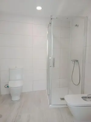 a white bathroom with a shower and a toilet at A Ledicia de Ana in Viveiro