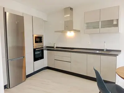 a kitchen with white cabinets and a stainless steel refrigerator at A Ledicia de Ana in Viveiro