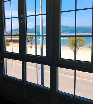 a view of a beach from a window at La casa de Concha in Viveiro