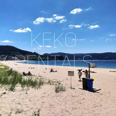 a beach with people playing volleyball on the sand at La casa de Concha in Viveiro