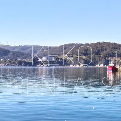 a large body of water with a red boat in it at La casa de Concha in Viveiro