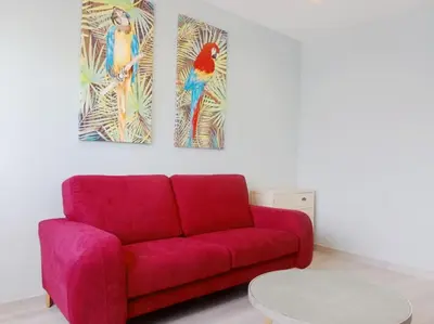 a red couch in a living room with two paintings at La casa de Concha in Viveiro