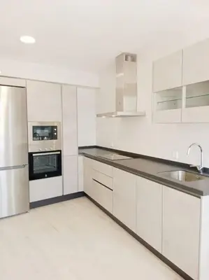 a white kitchen with white cabinets and appliances at La casa de Concha in Viveiro