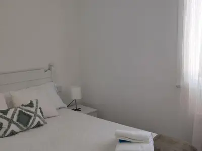 a bedroom with a white bed with a towel on it at Casa Dina II. in Carballino