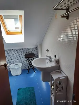 a bathroom with a white sink and a blue floor at Mondariz Donde el Agua es Vida in Mondariz