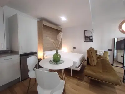 a bedroom with a bed and a table and chairs at 1A. Estudio para disfrutar y tapear en Ourense in Ourense