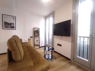 a living room with a couch and a flat screen tv at 1A. Estudio para disfrutar y tapear en Ourense in Ourense