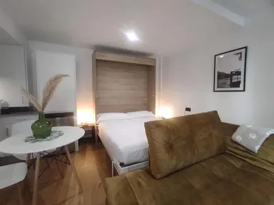 a bedroom with a bed and a couch and a table at 1A. Estudio para disfrutar y tapear en Ourense in Ourense