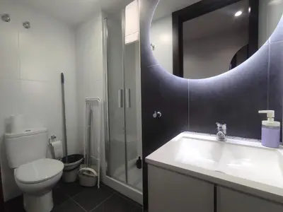 a bathroom with a toilet and a sink and a mirror at 1A. Estudio para disfrutar y tapear en Ourense in Ourense