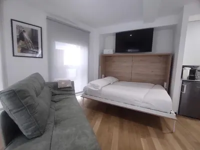 a living room with a couch and a bed at 1B. Estudio muy luminoso en el corazón del tapeo. in Ourense