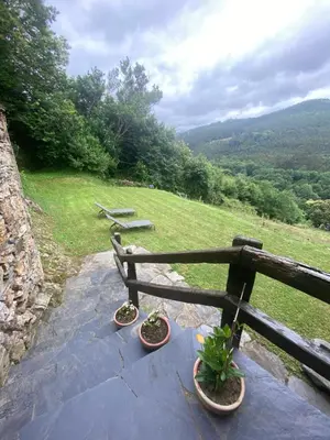 a bench with two potted plants sitting on a patio at Casa da Costa de Sueiro in Sueiro