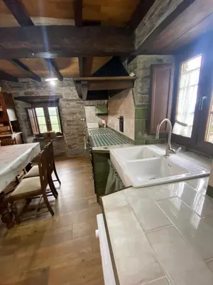 a large kitchen with a sink and a table at Casa da Costa de Sueiro in Sueiro
