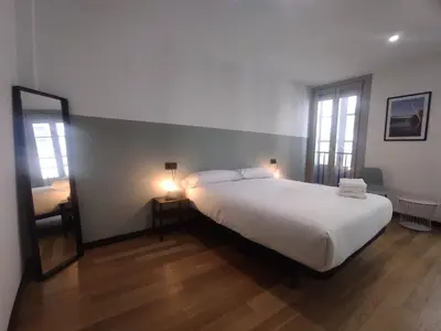 a bedroom with a large white bed and a mirror at 2. Luminoso y único en la mejor zona gastronómica in Ourense