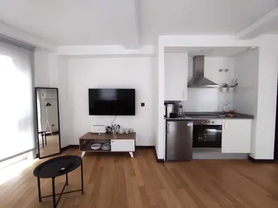 a living room with a kitchen and a television in it at 2. Luminoso y único en la mejor zona gastronómica in Ourense