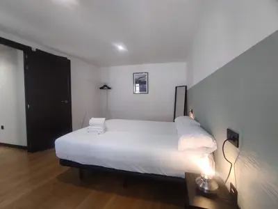 a bedroom with a white bed and a table with a lamp at 3. Amplio y muy luminoso para disfrutar de Ourense in Ourense