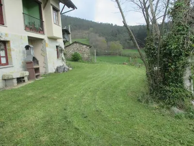 a yard next to a house with a tree at Casa de Aldea Carboneiro in Naraval