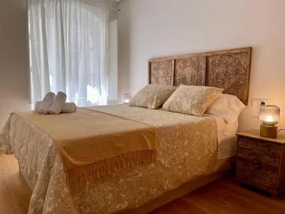 a bedroom with a bed with two pillows and a window at Piso Principal in Ourense