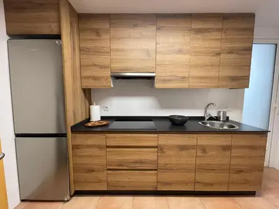a kitchen with wooden cabinets and a refrigerator at Piso Principal in Ourense
