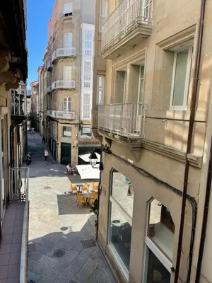 an alley in a city with tables and buildings at Piso Principal in Ourense