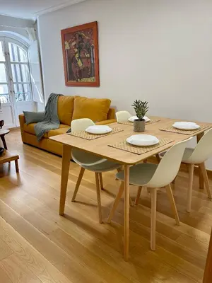 a living room with a table and a couch at Piso Principal in Ourense
