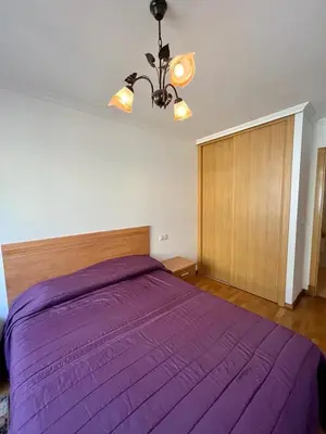 a bedroom with a purple bed with a wooden headboard at Playa grande Miño travesía in Miño