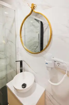 a bathroom with a white sink and a mirror at Apartamentos Luis in Arzúa