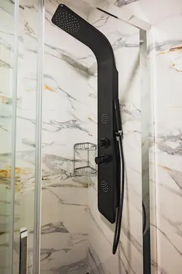 a shower door opener in a bathroom with a marble wall at Apartamentos Luis in Arzúa