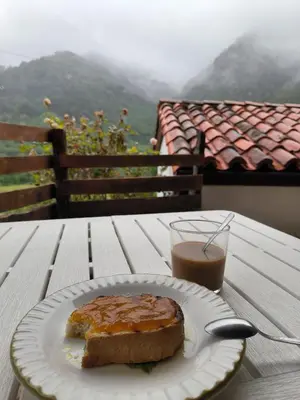 a plate with a piece of bread and a drink on a table at Casa La Parra in Villar de Vildas