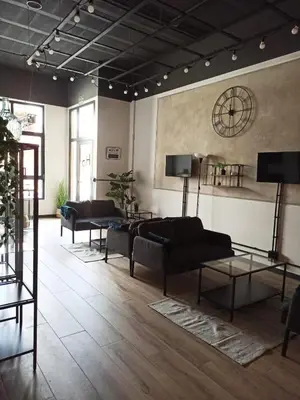 a living room with couches and a clock on the wall at Albergue HR in Sarria