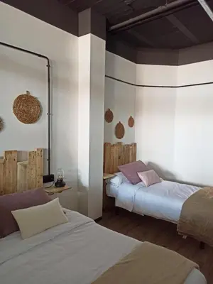 a bedroom with two beds and a mirror at Albergue HR in Sarria