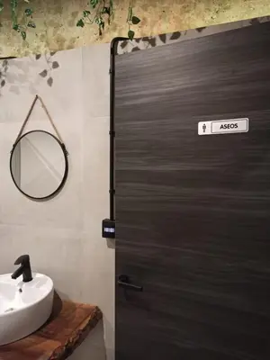 a bathroom with a door with a sink and a mirror at Albergue HR in Sarria