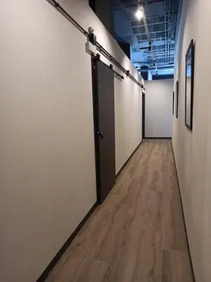 an empty hallway with white walls and a door at Albergue HR in Sarria