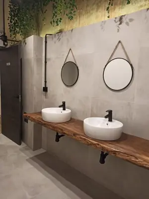 a bathroom with two sinks and two mirrors on the wall at Albergue HR in Sarria