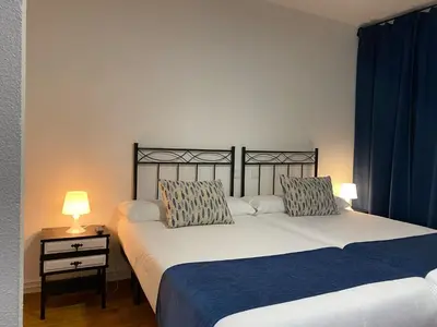 two beds sitting next to each other in a room at Hostal La Trucha Sanabria in Puebla de Sanabria