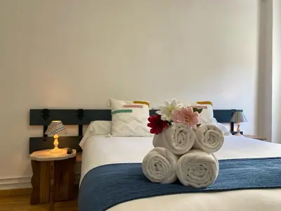 a bedroom with a bed with towels on it at Hostal La Trucha Sanabria in Puebla de Sanabria