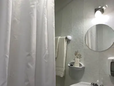 a bathroom with a white shower curtain and a sink at Hostal La Trucha Sanabria in Puebla de Sanabria