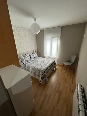 a bedroom with a bed and a chair in it at Carlos III Foz in Foz