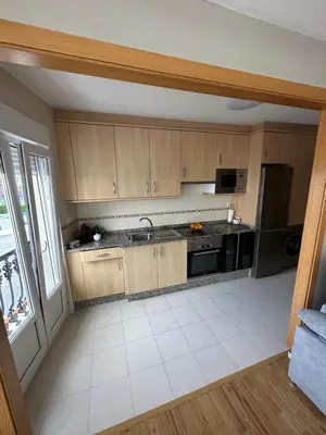 a kitchen with wooden cabinets and a stainless steel refrigerator at Carlos III Foz in Foz