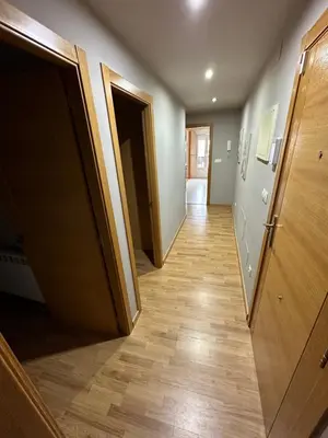 a hallway with two open doors and wooden floors at Carlos III Foz in Foz