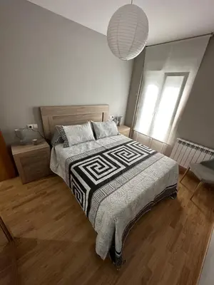 a bedroom with a bed with a black and white comforter at Carlos III Foz in Foz