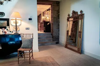 a room with a chair and a mirror and stairs at Villa Los Magnolios in Paderne