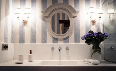 a bathroom with a sink and a mirror and flowers at Villa Los Magnolios in Paderne