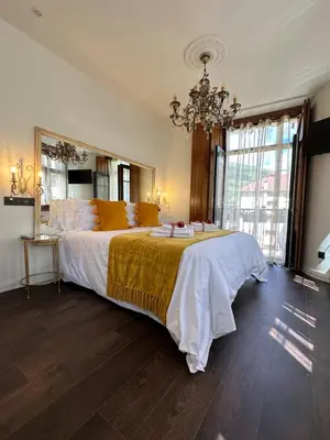 a bedroom with a large bed with a chandelier at CLAREN´S BOUTIQUE ROOMS in Cangas del Narcea