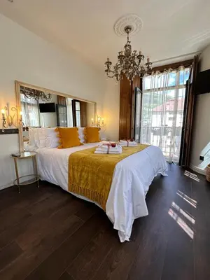 a bedroom with a large bed with a chandelier at CLAREN´S BOUTIQUE ROOMS in Cangas del Narcea