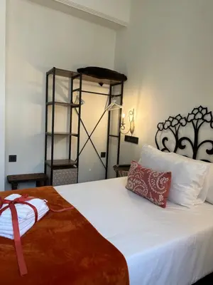 a bedroom with a white bed with a red pillow on it at CLAREN´S BOUTIQUE ROOMS in Cangas del Narcea