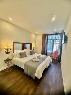 a bedroom with a large bed and a large window at CLAREN´S BOUTIQUE ROOMS in Cangas del Narcea