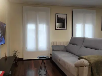 a living room with a couch and a table at 1A. Disfruta de su balcón sobre el casco viejo. in Ourense