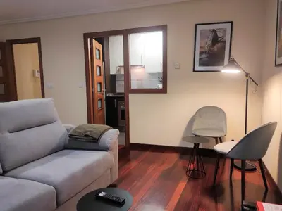 a living room with a couch and a chair at 1A. Disfruta de su balcón sobre el casco viejo. in Ourense