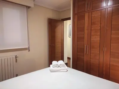 a bedroom with a bed with white towels on it at 1A. Disfruta de su balcón sobre el casco viejo. in Ourense