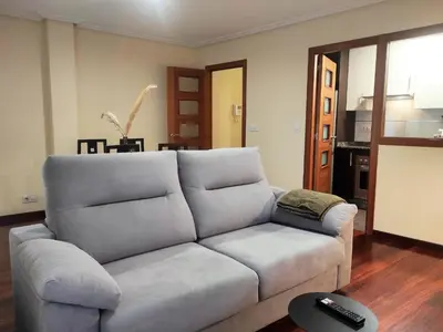 a living room with a couch and a kitchen at 1A. Disfruta de su balcón sobre el casco viejo. in Ourense
